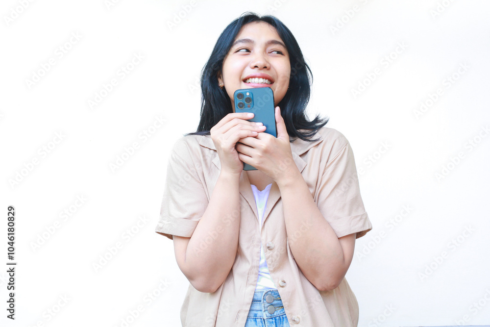 excited asian woman using smartphone and looking away wearing casual brown isolated on white excited asian woman using smartphone and looking away wearing casual brown isolated on white