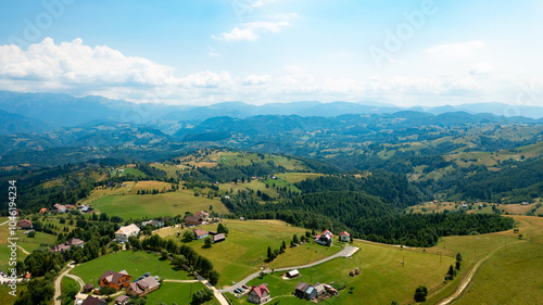 Aerial View of a Romanian Field Surrounded by Forest and Houses