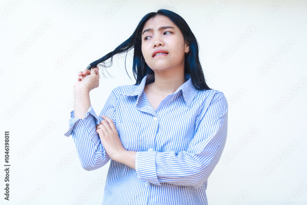 confused asian woman look thoughtful holding her hair and folded arms wearing striped shirt isolated on white background confused asian woman look thoughtful holding her hair and folded arms wearing striped shirt isolated on white background