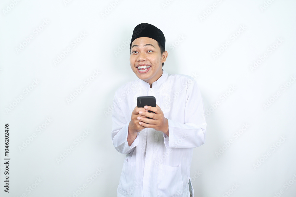 funny and amazed face of muslim asian man holding phone with looking at camera funny and amazed face of muslim asian man holding phone with looking at camera