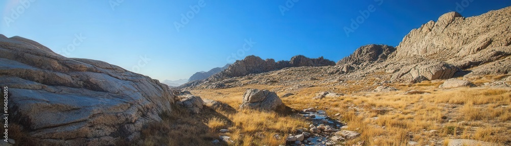 Mountain image of a rugged, rocky landscape with a clear blue sky above, a small mountain stream winding through the foreground Mountain image of a rugged, rocky landscape with a clear blue sky above, a small mountain stream winding through the foreground