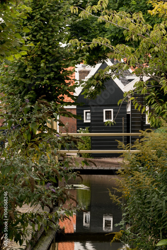 Quiet smooth waters in canal in old neighborhood in Volendam - 3 photo