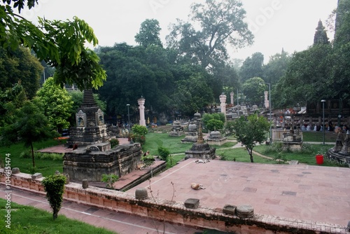 numbers of votive stupas, meditating pilgrims, visitors and lots of tranquility inside the garden space of temple premises of 