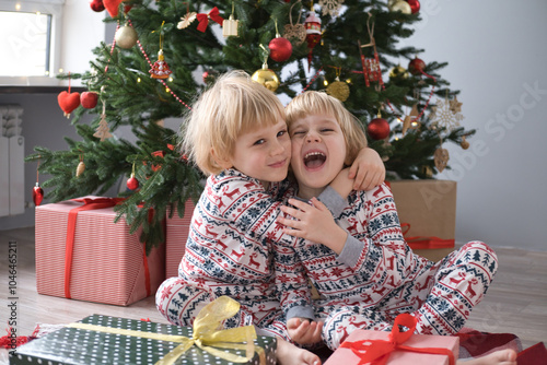 cute kids in Christmas pajamas with gift boxes at christmas morning