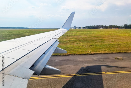 View from Airplane Window Overlooking Runway and Countryside Horizon photo