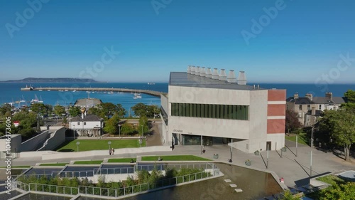 LexIcon, Dún Laoghaire, County Dublin, Ireland, September 2024. Drone descends in a gentle clockwise orbit around the sleek modern building facing Dublin Bay on beautiful day under a clear blue sky. photo