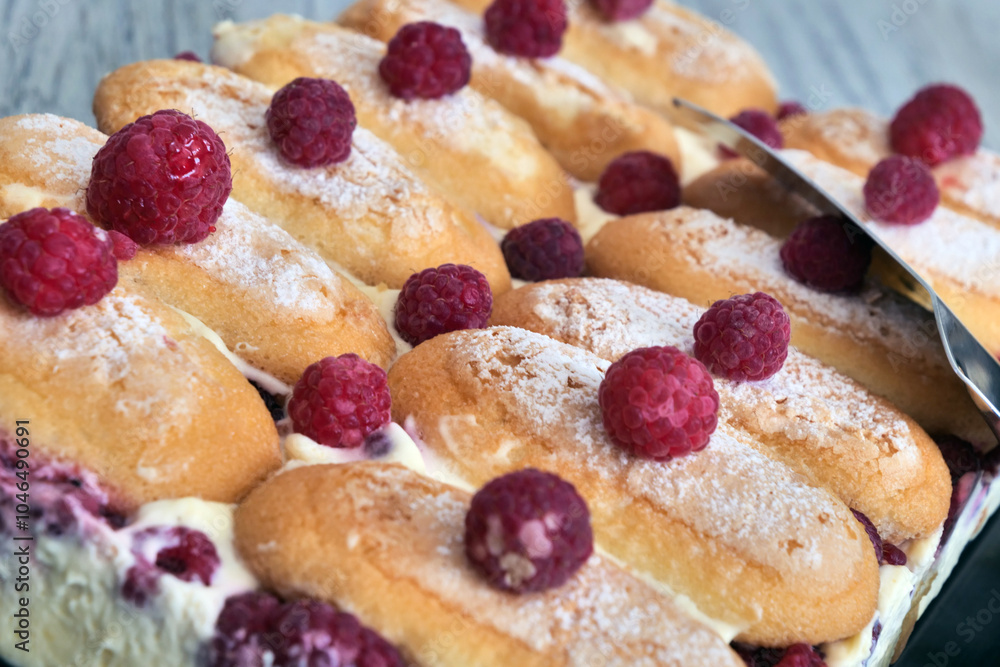 A tray of pastries with raspberries on top A tray of pastries with raspberries on top