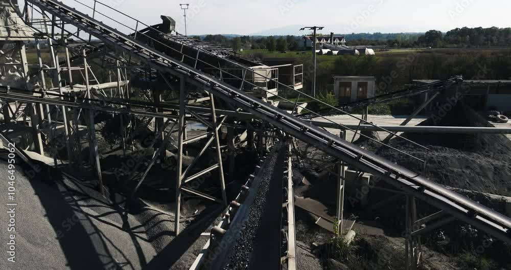 Rock crusher plant, machine at work process, drone flying above a conveyor belt during transporting gravel, tracking shot, cinema look Rock crusher plant, machine at work process, drone flying above a conveyor belt during transporting gravel, tracking shot, cinema look