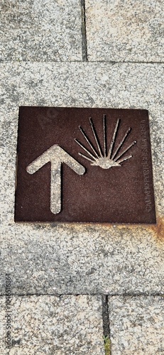 Camino to Santiago de Compostela with tipycal sign scallop shell and arrow photo