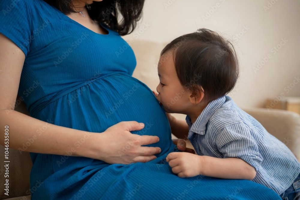 Little boy kisses his mother's pregnant belly, expressing excitement and love for his soon-to-arrive sibling. Family anticipation concept Little boy kisses his mother's pregnant belly, expressing excitement and love for his soon-to-arrive sibling. Family anticipation concept