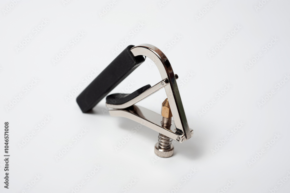 Modern technological, metal capo with a spring clamp for guitar. Modern technological, metal capo with a spring clamp for guitar.