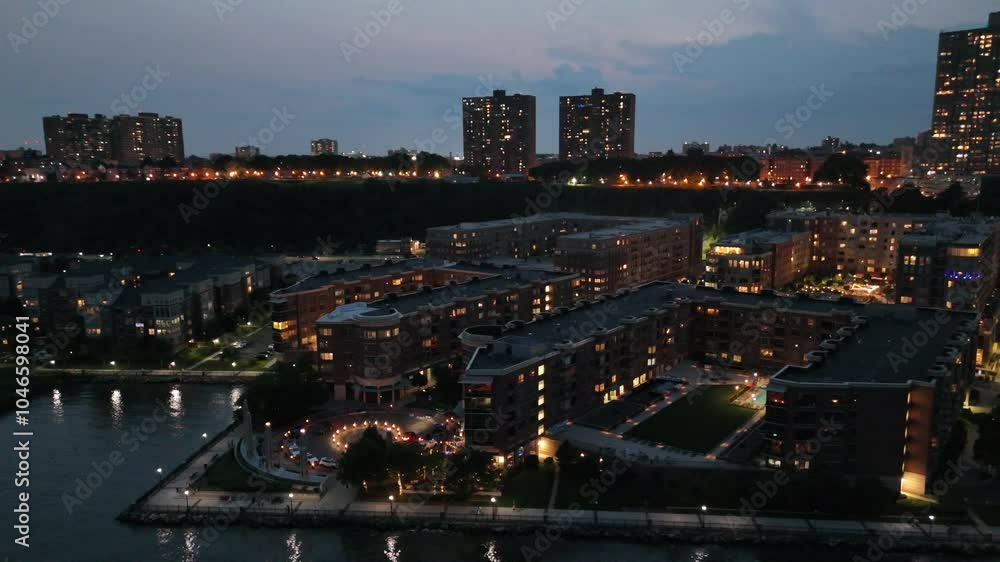 Drone view of illuminated skyline with a waterfront at sunset with cloudy sky background in New York Drone view of illuminated skyline with a waterfront at sunset with cloudy sky background in New York