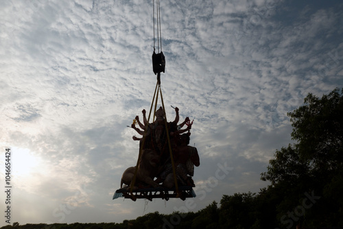 Katni , India - 12 October 2024 The idol of goddess Durga Maa is being lifted by a crane and taken to the pond for immersion at Kymore in Katni Madhya Pradesh India photo