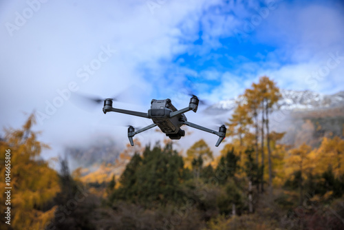 Flying drone taking photo of autumn forest landscape and snow capped mountains