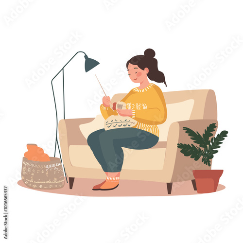A pregnant woman knitting baby booties on a couch