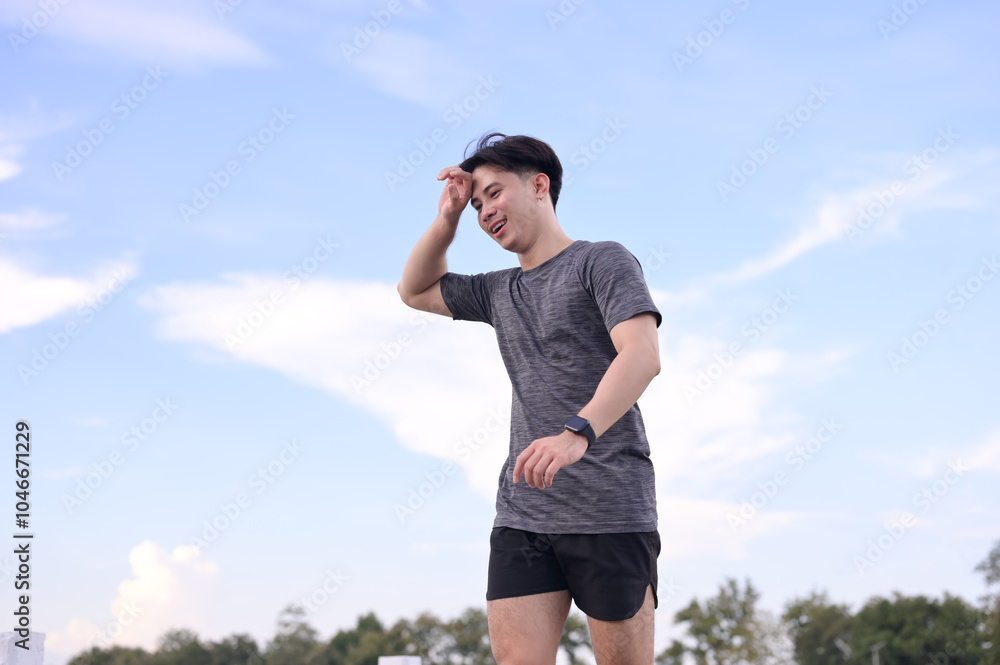 Smiling young sporty man jogging on a path surrounded by nature Smiling young sporty man jogging on a path surrounded by nature