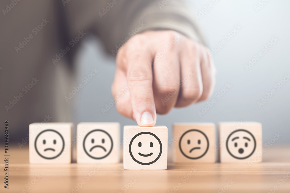 A man choosing between a happy and sad face on wooden blocks, ultimately selecting the happy one. The concept of starting each day with positivity, emphasizing the importance of a bright outlook A man choosing between a happy and sad face on wooden blocks, ultimately selecting the happy one. The concept of starting each day with positivity, emphasizing the importance of a bright outlook