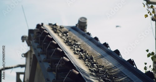 The conveyor belt transports rocks, stone crusher plant machine at work process, shallow depth of field, close-up. photo