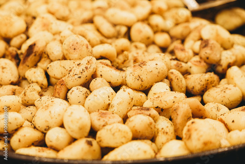 Baked potatoes in large dish - outdoor food festival photo