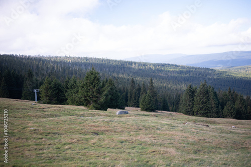 Autumn landscapes in the mountains of Szklarska Poręba, Poland, feature vibrant foliage, misty peaks, and peaceful trails surrounded by golden and red hues. photo