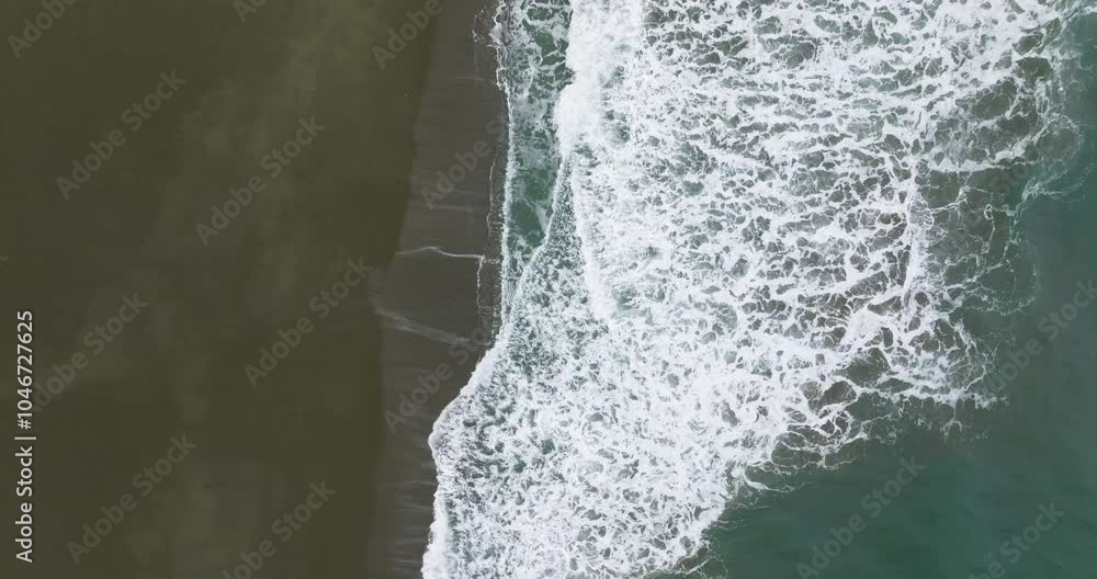 Side view of waves breaking right to left on Oregon Coast beach, overhead view, flying forward along edge of surf. Side view of waves breaking right to left on Oregon Coast beach, overhead view, flying forward along edge of surf.
