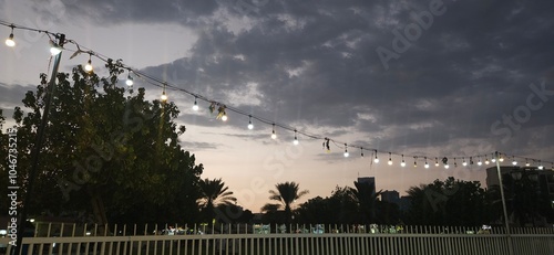Serene outdoor scene with a string of lights hanging above. soft diffused light, evening time