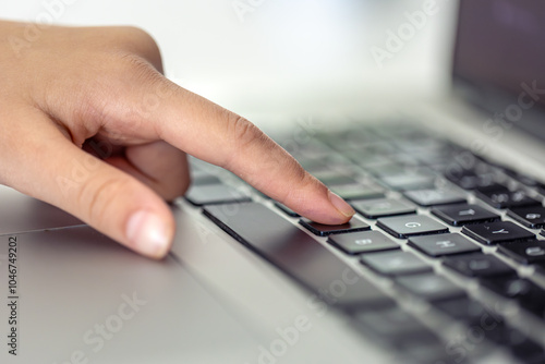 The girl is typing on the laptop keyboard. Girl's hands on the keyboard.