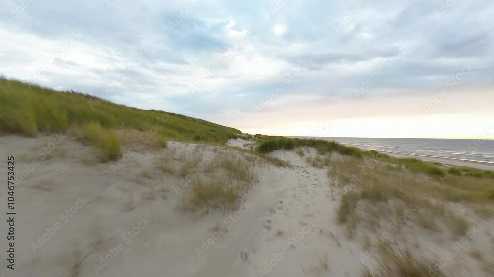 Aerial FPV drone flying through sandy beach dunes at the island of Texel, The Netherlands. Aerial FPV drone flying through sandy beach dunes at the island of Texel, The Netherlands.