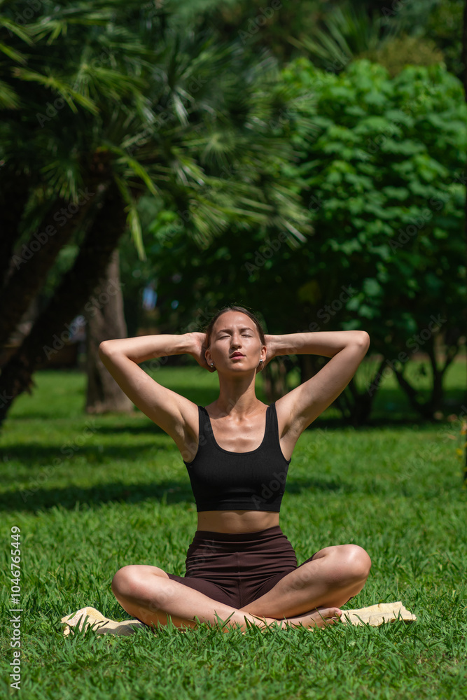 Young woman in sportswear practices yoga poses in lush green park, highlighting her flexibility and mindfulness while embracing tranquility of nature. Sports lifestyle, health. Vertical photo Young woman in sportswear practices yoga poses in lush green park, highlighting her flexibility and mindfulness while embracing tranquility of nature. Sports lifestyle, health. Vertical photo