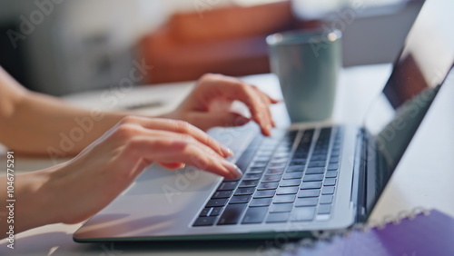 Hands pressing laptop keyboard on office desk at morning closeup. Unknown woman