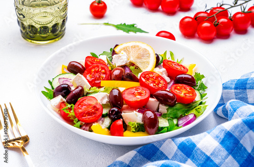 Mediterranean salad with vegetables, olives, cheese and lettuce, white background, top view