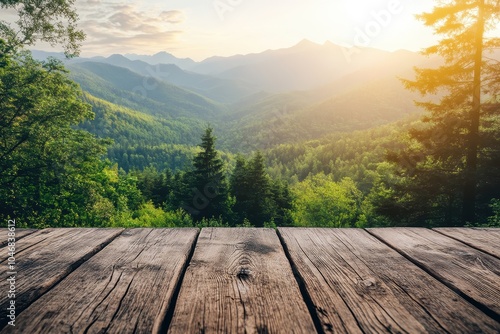 A wooden table top overlooking a scenic vista of mountain ranges and lush green forest at sunset.