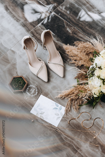 Luxury details of wedding accessories. Arrangement on the floor of marble bouquet, invitations, shoes and jewelry