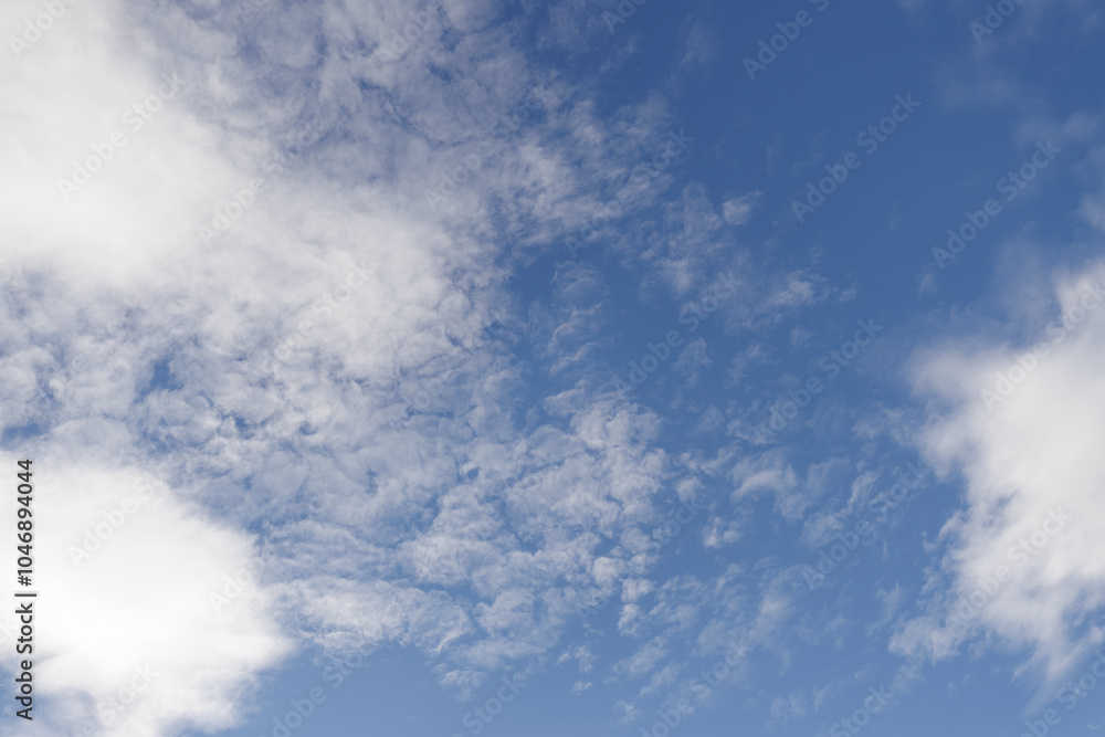 White cirrocumulus clouds are forming on a deep blue sky, creating a beautiful natural pattern White cirrocumulus clouds are forming on a deep blue sky, creating a beautiful natural pattern