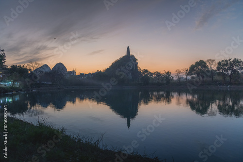 Pagoda and the city buildings surrounded by the limestone mountains, Guilin, China photo