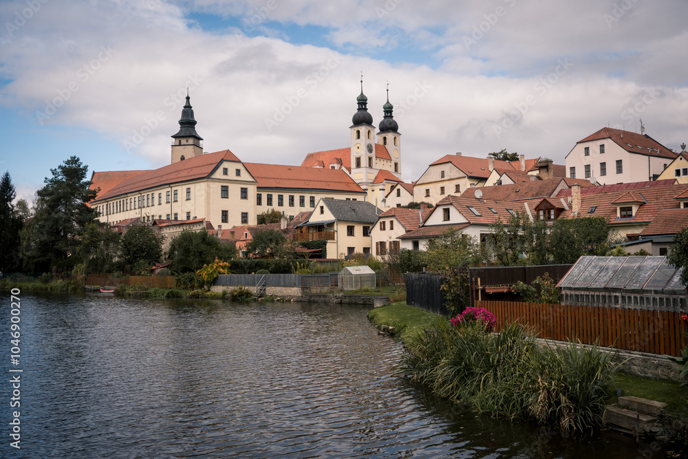 Fototapeta premium View of Jesuit College and Historic Telč with Pond on a Partly Cloudy Autumn Morning