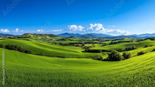 Vibrant green landscape under a clear blue sky, showcasing rolling hills and distant mountains, perfect for nature themes.
