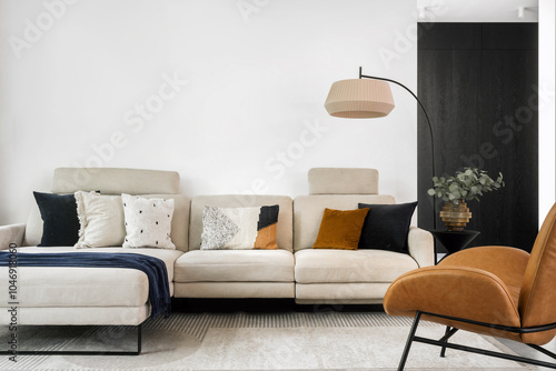 Modern living room with a beige sofa, decorative cushions, and stylish lighting