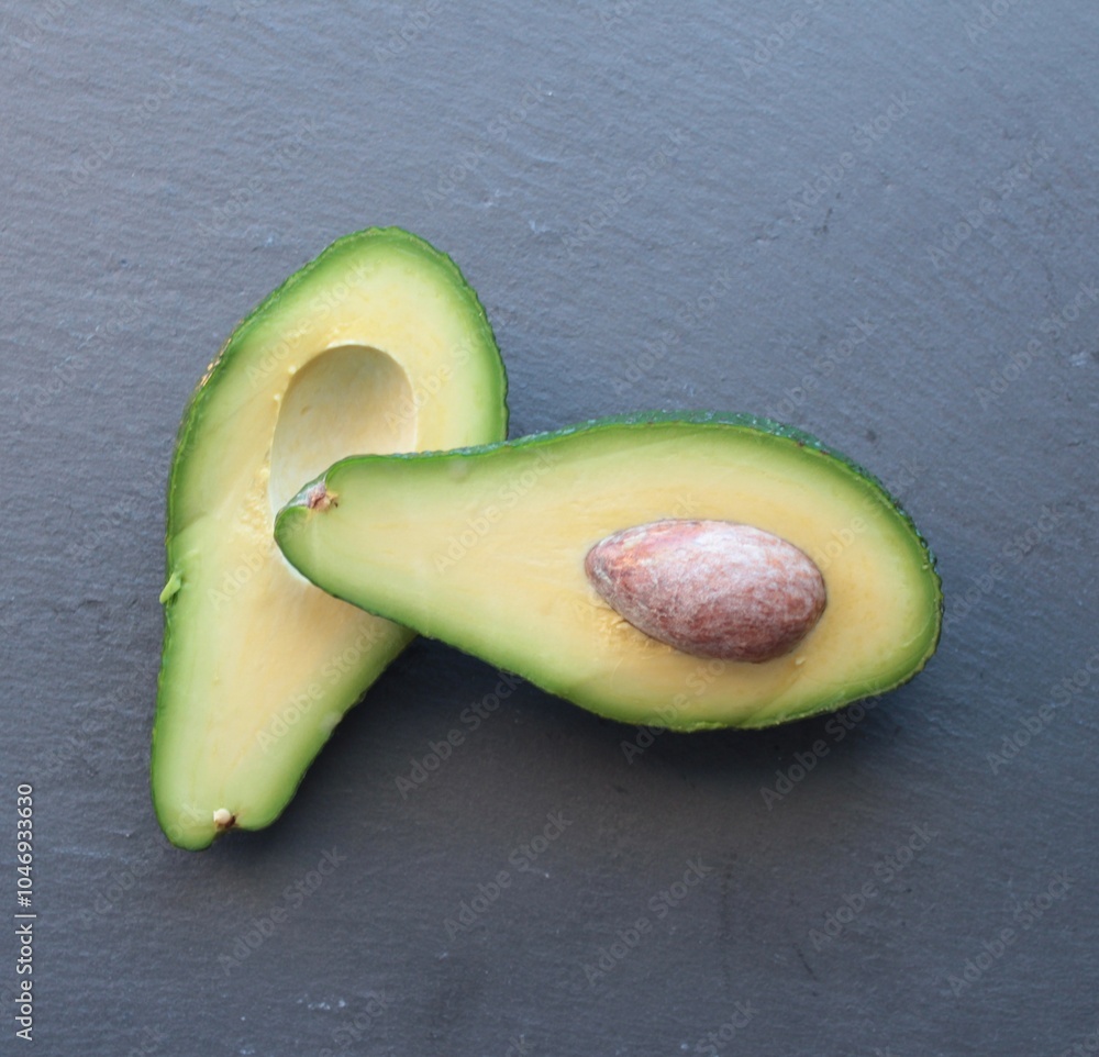 © Sarah - avocado cut in half on a black stone background