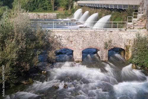 Water jets. Rough river waters.Water rushes furiously at the exit of a power plant. Italy photo