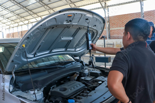 Men working on vehicle inspection with mechatronic equipment