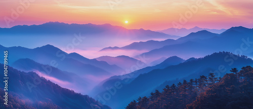 Towering mountain peaks partially veiled in mist, with sunlight breaking over the horizon, casting a warm glow over rugged terrain.