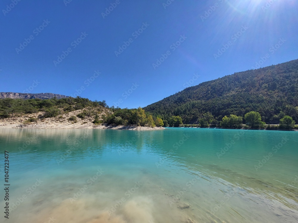 Turquoise Lake with Mountain Backdrop under Clear Blue Sky in Europe Turquoise Lake with Mountain Backdrop under Clear Blue Sky in Europe