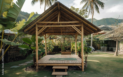 A peaceful bamboo shelter in a tropical garden, with a yoga mat on a wooden deck, enveloped by green foliage and the soothing sounds of nature. photo