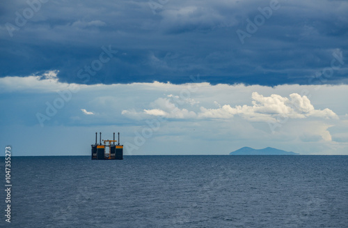 Oil rig under stormy clouds in the Thyrrenian Sea photo