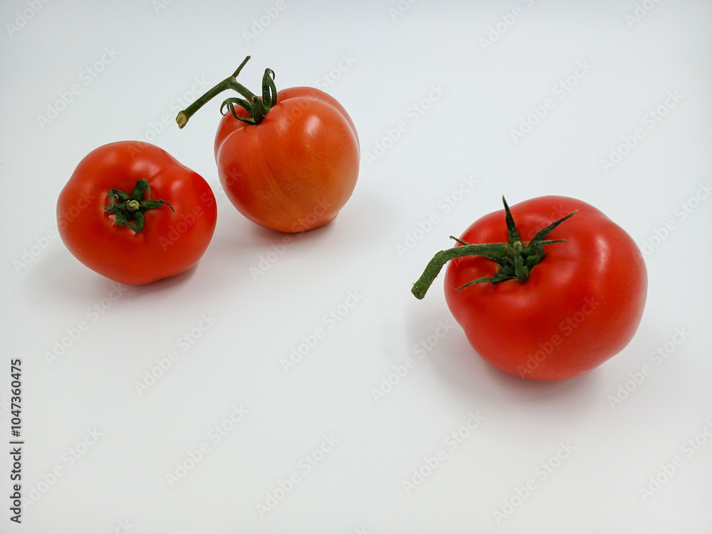 Red tomato with green branches and leaves. The vegetable from the farm. A fresh juicy product. Sauces, ketchup are made from it. Culinary theme, catalog, food packaging for a supermarket or blog. Red tomato with green branches and leaves. The vegetable from the farm. A fresh juicy product. Sauces, ketchup are made from it. Culinary theme, catalog, food packaging for a supermarket or blog.