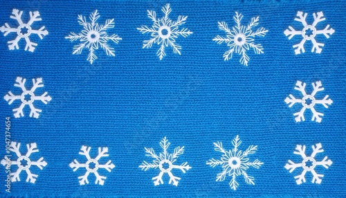 Decorative snowflake pattern in white against blue knitted texture background