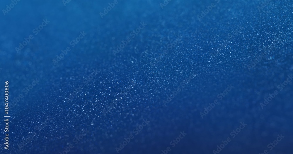 Obraz premium A deep blue background covered with densely packed shimmering particles, creating a textured surface with DOF. ideal for tech presentations, futuristic visuals, or modern digital product backgrounds.