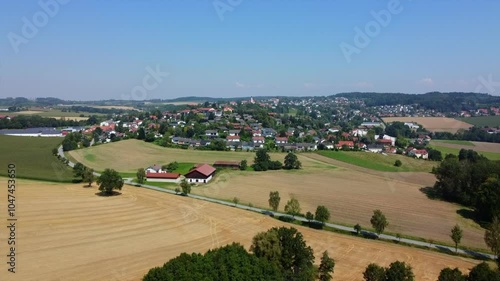 Beautiful view of Bad Griesbach village, surrounded by golden fields, trees, and hills in Lower Bavaria, with traditional Bavarian architecture on a sunny summer day. photo