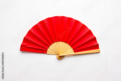 Red hand fan with bamboo frame on white background